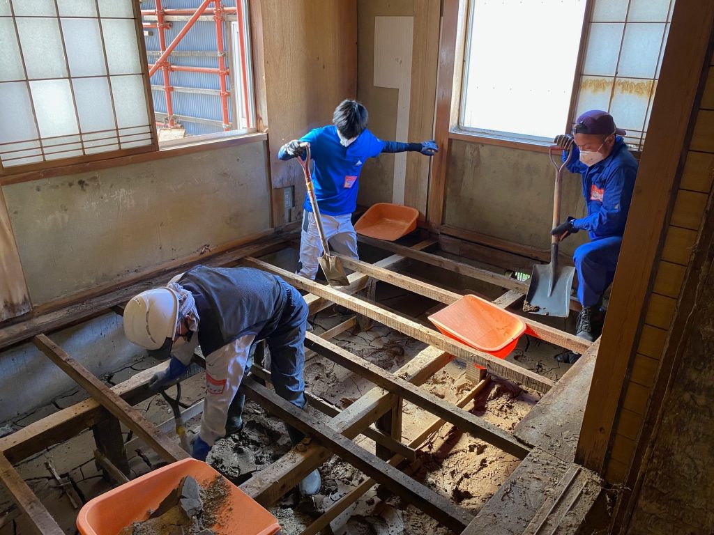 栗駒山麓ジオパークの皆さんと床下に入り込んだ泥を撤去している様子
